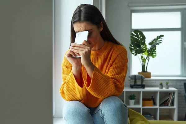 Depressed Woman Hiding Face Smart Phone While Sitting Window Sill — Foto de Stock