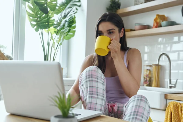 Attractive Young Woman Enjoying Morning Coffee Using Laptop Domestic Kitchen — Stock Fotó