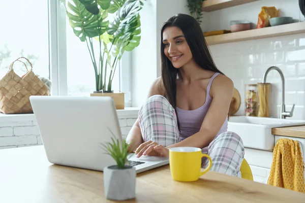 Beautiful Woman Using Laptop While Sitting Kitchen Counter Home — Stockfoto