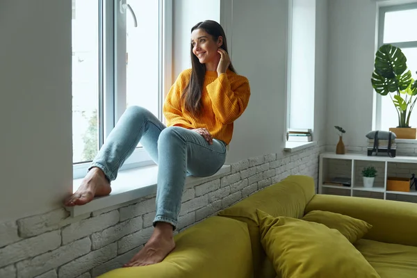 Dreamful Young Woman Looking Window While Sitting Window Sill Home — Fotografia de Stock