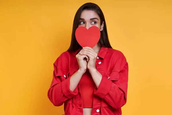 Beautiful Young Woman Covering Mouth Paper Heart Hand Yellow Background — Stock Photo, Image