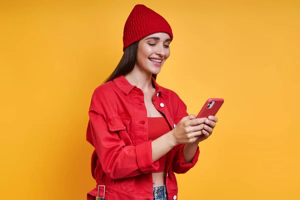 Beautiful Young Woman Red Hat Using Smart Phone Yellow Background — Stock Photo, Image