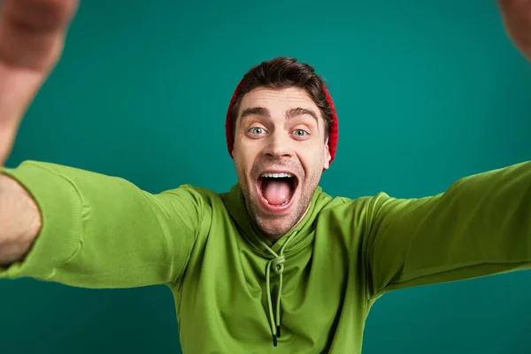 Excited Young Man Looking Finger Frame While Standing Green Background — Zdjęcie stockowe