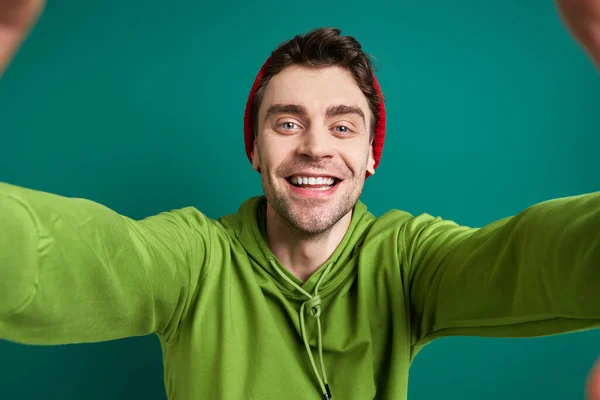 Счастливый Молодой Человек Смотрит Сквозь Рамку Пальца Стоя Зеленом Фоне — стоковое фото