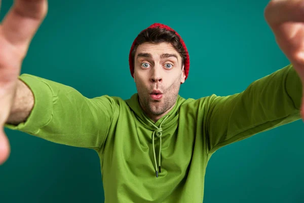 Surprised Young Man Looking Finger Frame While Standing Green Background — Stock fotografie