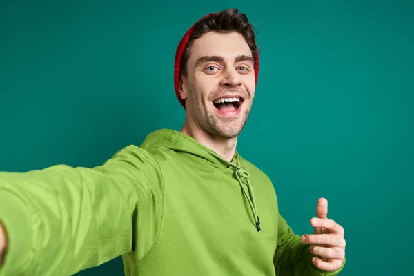 Счастливый Молодой Человек Делает Селфи Стоя Зеленом Фоне — стоковое фото