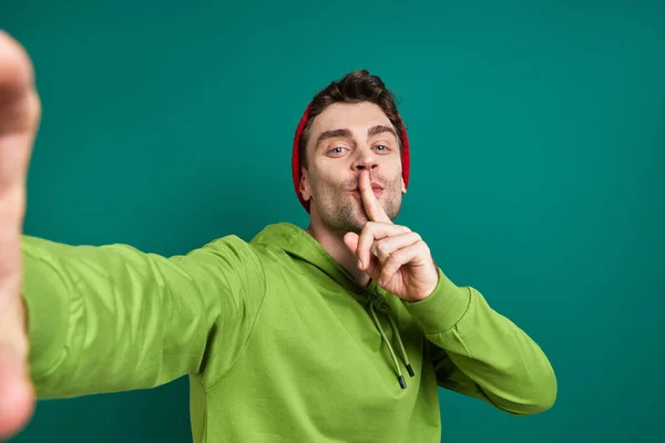 Handsome Man Making Selfie Holding Finger Lips While Standing Green — Foto Stock