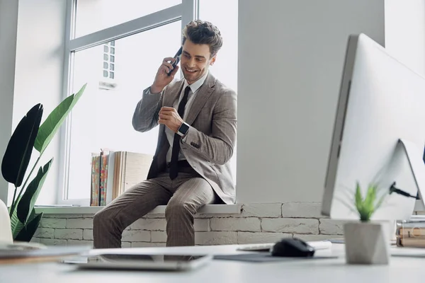 Handsome Man Talking Mobile Phone Smiling While Sitting Window Sill — Stockfoto