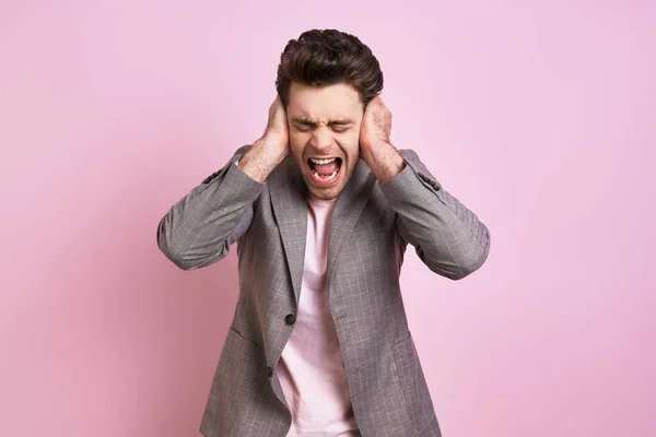 Frustrated Man Covering Ears Hands Shouting While Standing Pink Background — Stock Fotó