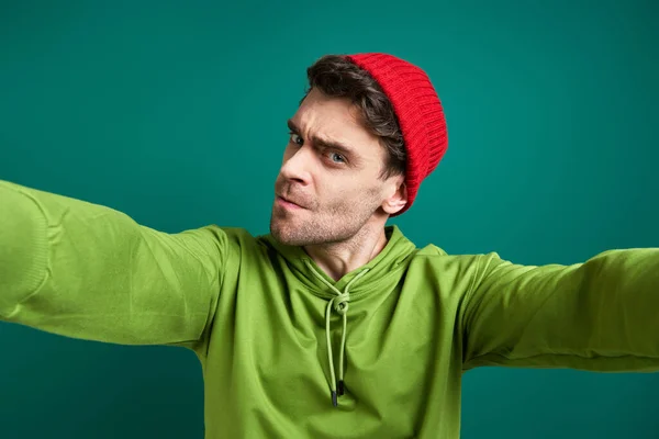 Angry Young Man Stretching Out Hands While Standing Green Background — Photo