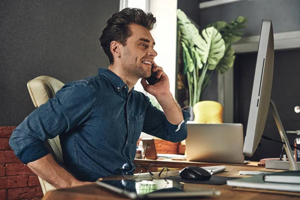 Happy Young Man Talking Mobile Phone While Sitting His Working — Stockfoto