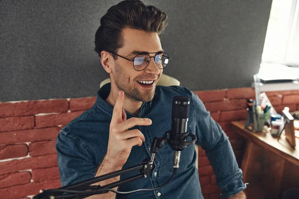 Happy Young Man Using Microphone Gesturing While Recording Podcast Studio — Stok fotoğraf