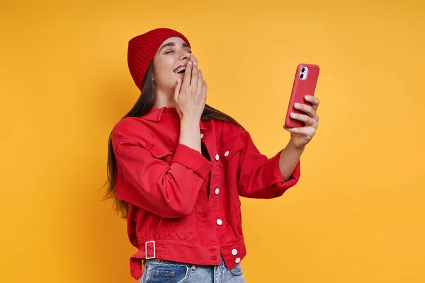 Happy Young Woman Holding Smart Phone Covering Mouth Hand Yellow — 스톡 사진