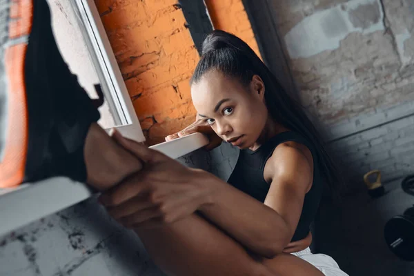 Confident Woman Sports Clothing Using Window Sill While Doing Stretching — Stok fotoğraf