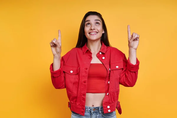 Happy Young Woman Pointing While Standing Yellow Background — Stock Photo, Image