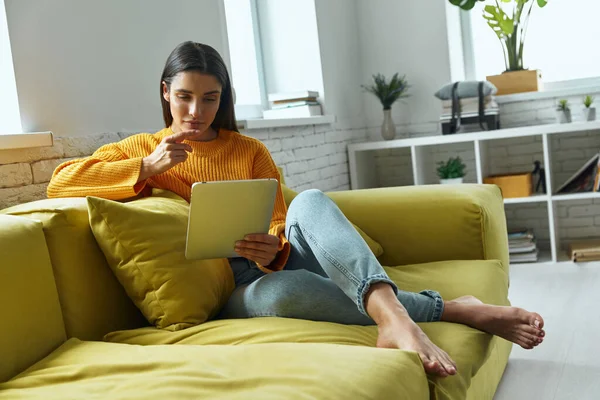 Confident Young Woman Using Digital Tablet While Sitting Couch Home — Foto de Stock