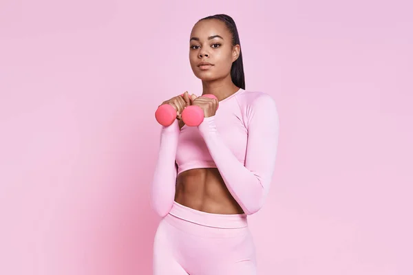 Beautiful Young African Woman Holding Dumbbells While Standing Pink Background —  Fotos de Stock