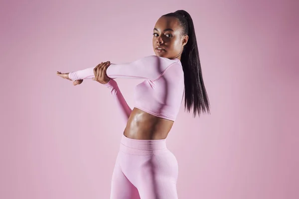 Confident Young Woman Sports Clothing Doing Stretching Exercises Pink Background — 스톡 사진