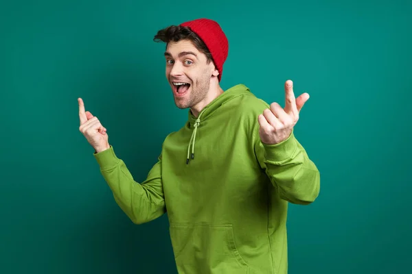 Playful Young Man Gesturing While Standing Green Background — Foto de Stock