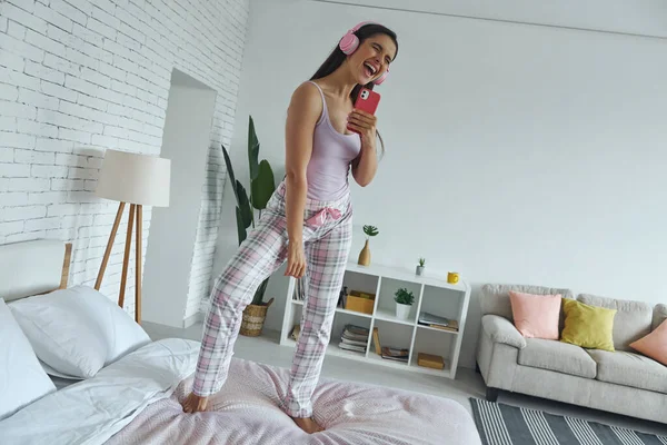 Happy Woman Headphones Using Smart Phone Microphone While Dancing Bed — Stock Fotó