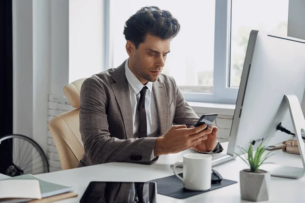 Confident Young Man Using Smart Phone While Sitting His Working — Photo