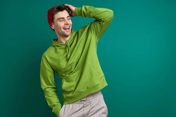 Handsome Young Man Adjusting His Hat Smiling While Standing Green — Stock fotografie