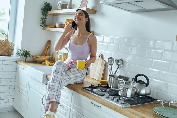 Happy Woman Talking Mobile Phone Enjoying Coffee While Sitting Kitchen — Stock Fotó