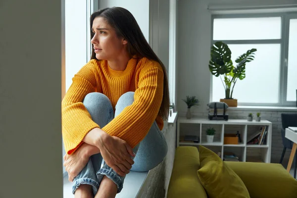 Depressed Young Woman Looking Window While Sitting Window Sill — Foto de Stock