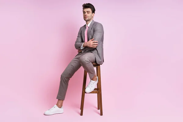 Άνθρωπος Αυτοπεποίθηση Πλήρη Κοστούμι Κάθεται Στην Καρέκλα Ροζ Φόντο — Φωτογραφία Αρχείου