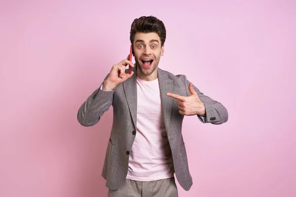 Excited Man Suit Talking Mobile Phone Pointing While Standing Pink — Stock fotografie