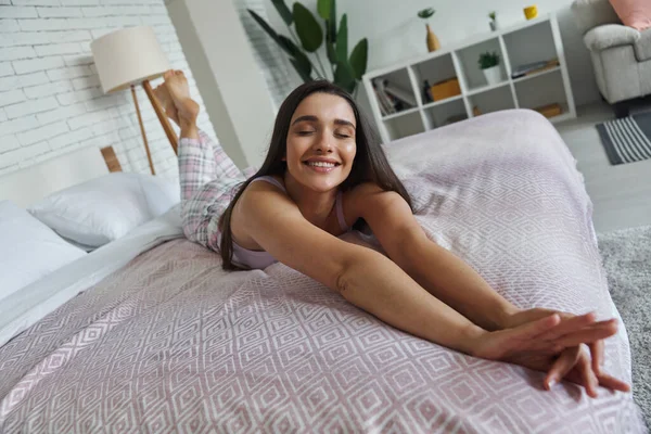 Relaxed Young Woman Stretching Out Hands While Lying Bed Home — Stock Fotó