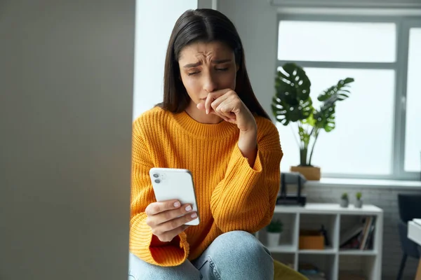Worried Woman Looking Her Smart Phone While Sitting Window Sill — Foto de Stock