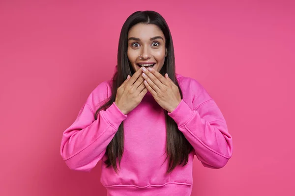 Surprised Young Woman Hooded Shirt Covering Mouth Hands Pink Background — Stock Photo, Image