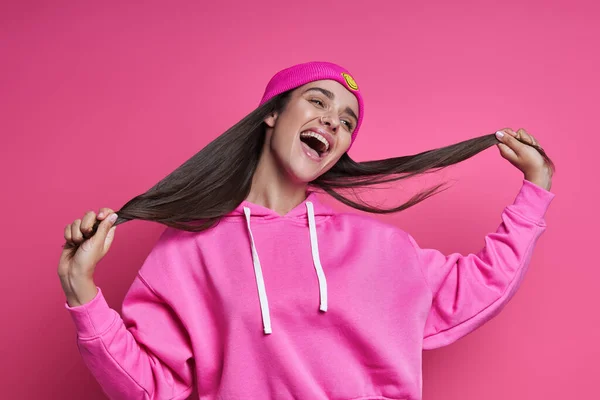 Excited Young Woman Hooded Shirt Holding Her Long Hair Pink — Foto de Stock