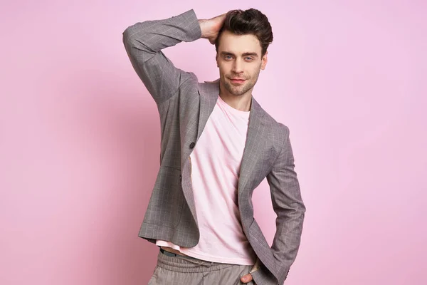 Confident Young Man Suit Holding Hand Hair While Standing Pink — Stockfoto