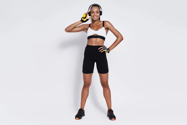 Happy African Woman Sports Clothing Adjusting Her Headphone White Background — Foto de Stock