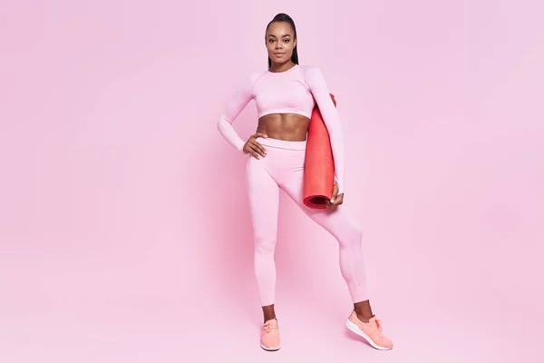 Beautiful African Woman Sports Clothing Carrying Exercise Mat Pink Background —  Fotos de Stock