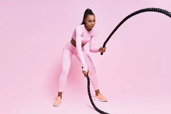 Concentrated Young African Woman Exercising Battle Ropes Pink Background — Foto de Stock