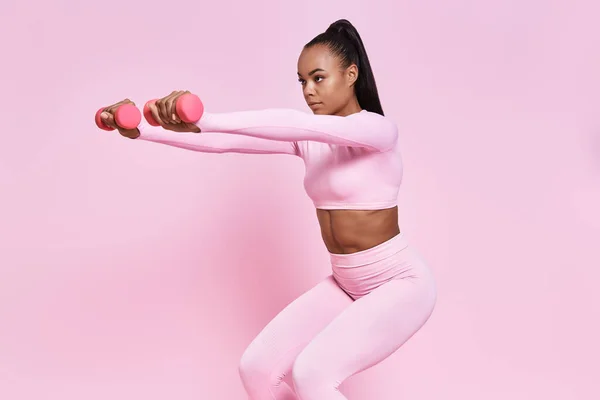 Attractive African Woman Exercising Dumbbells While Standing Pink Background —  Fotos de Stock