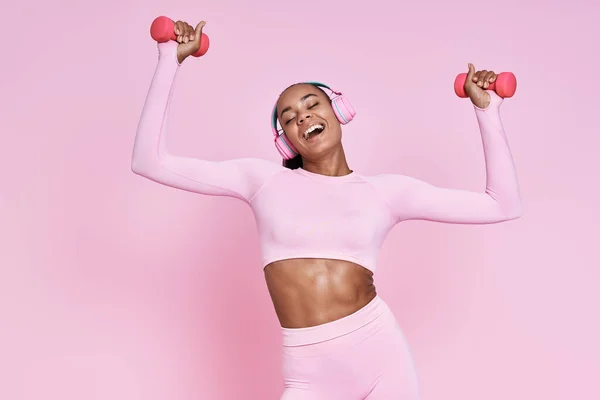 Beautiful Woman Headphones Exercising Dumbbells Smiling Pink Background — Photo
