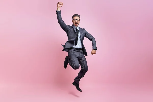 Excited Mature Man Full Suit Jumping Gesturing Pink Background - Stock-foto