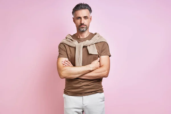 Fashionable Mature Man Keeping Arms Crossed While Standing Pink Background — Foto Stock