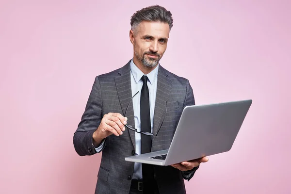 Confident Mature Man Formalwear Holding Laptop While Standing Pink Background — Fotografia de Stock