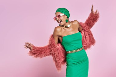 Geleneksel başlıklı mutlu Afrikalı kadın sarı arka planda dans ediyor