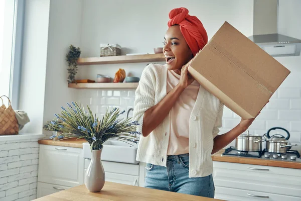 Spännande Afrikansk Kvinna Håller Pappkartong Nära Ansiktet Och Ler När — Stockfoto