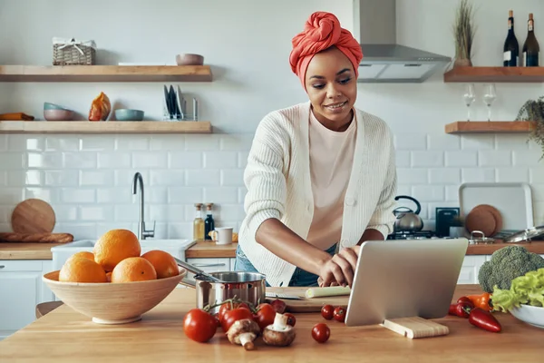 Jovem Africana Confiante Cozinhando Usando Tablet Digital Enquanto Está Cozinha — Fotografia de Stock