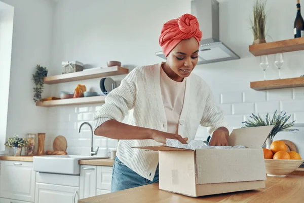 Güzel Afrikalı Kadın Evdeki Mutfakta Dururken Kutuları Açıyor — Stok fotoğraf
