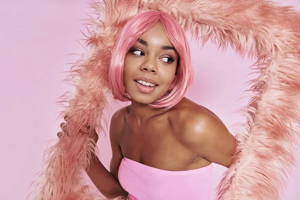 Красива Африканка Рожевим Волоссям Дивиться Крізь Пухнасту Раму Рожевому Фоні — стокове фото