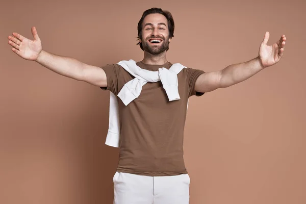 Cheerful Young Man Keeping Arms Outstretched Smiling Brown Background — Stock Photo, Image