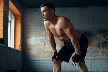 Spor salonundaki antrenmandan sonra el ele tutuşan kaslı bir adam.